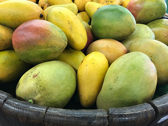 A large container holding a variety of mangoes.